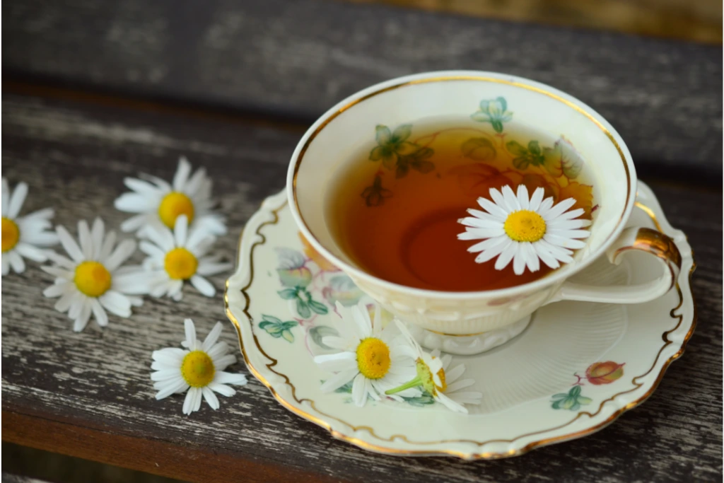 a cup of Chamomile Tea in vintage tea cup set with a chamomile flower