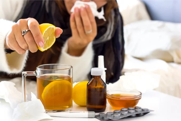 woman with a cold squeezing lemon in a cup