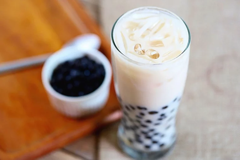 Coconut Milk Tea on a glass jar and a blurry bowl of tapioca pearls