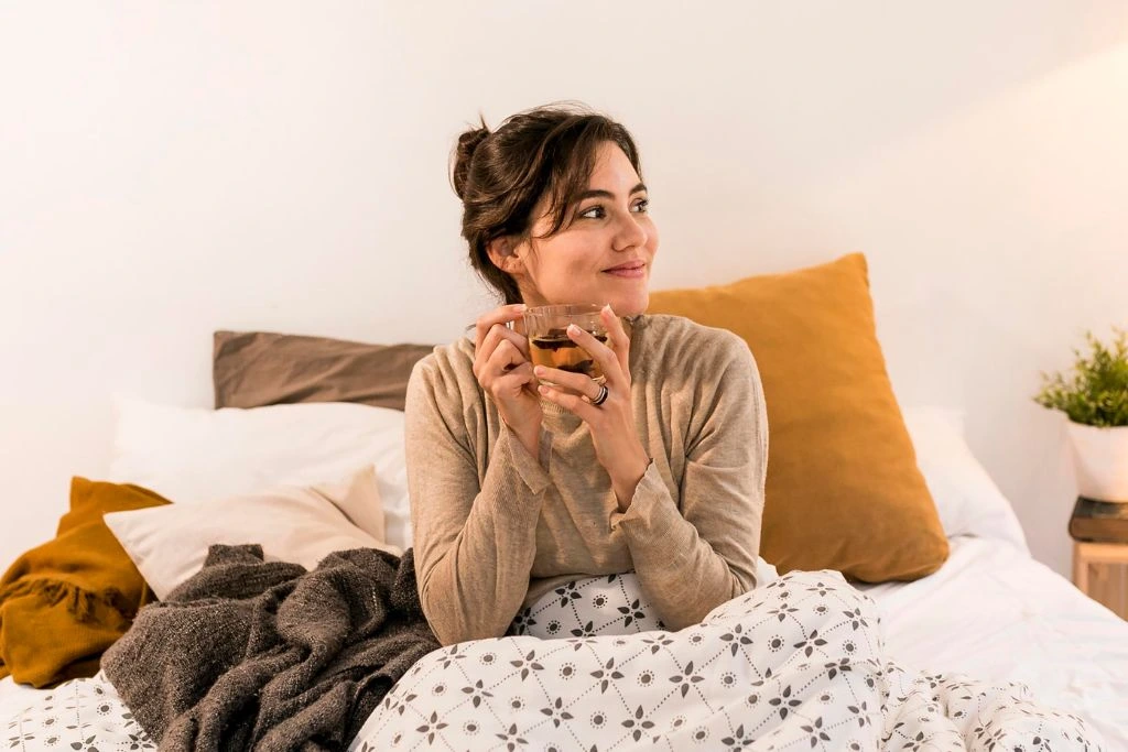 woman drinking her tea in bed