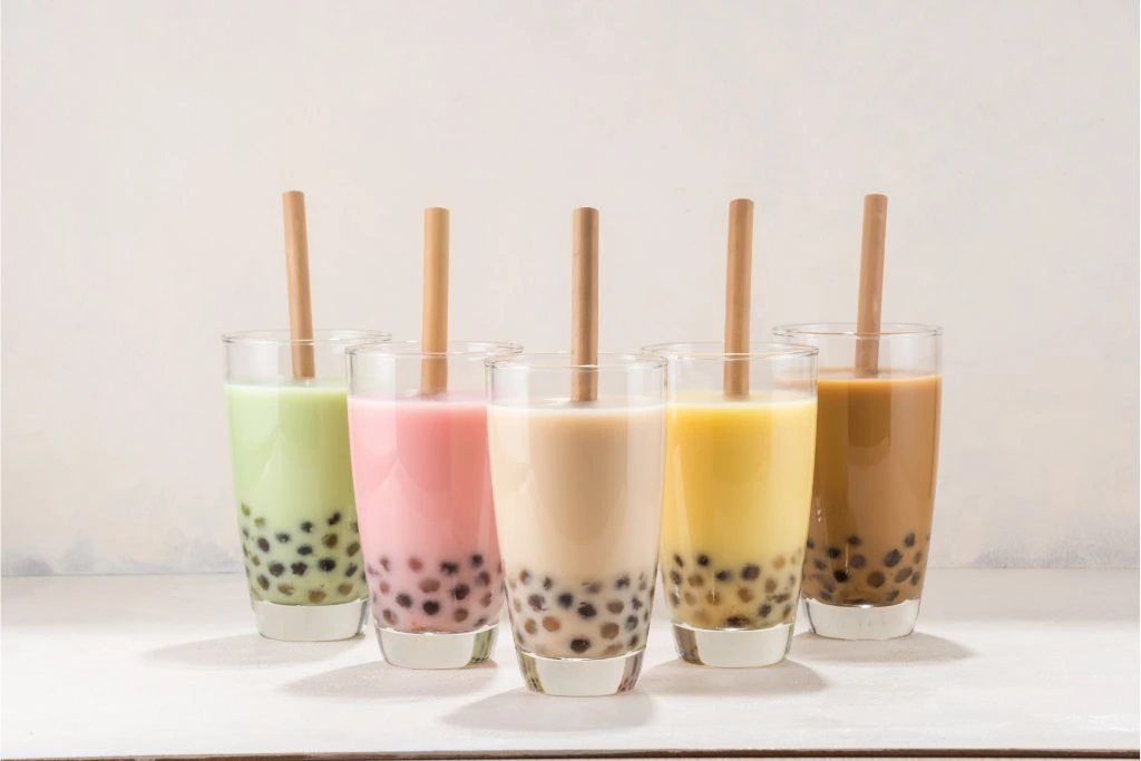 assorted flavors of boba milk tea on a white table