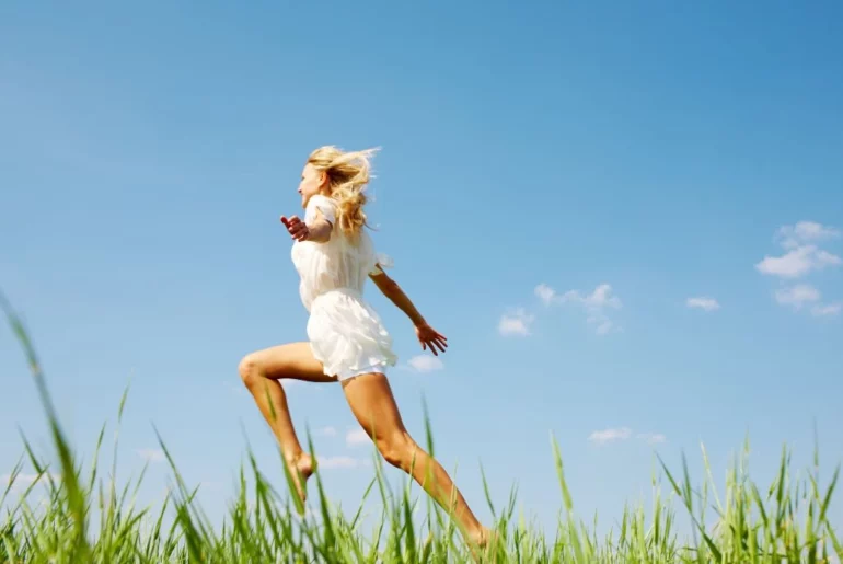 woman in wheatfield jumping