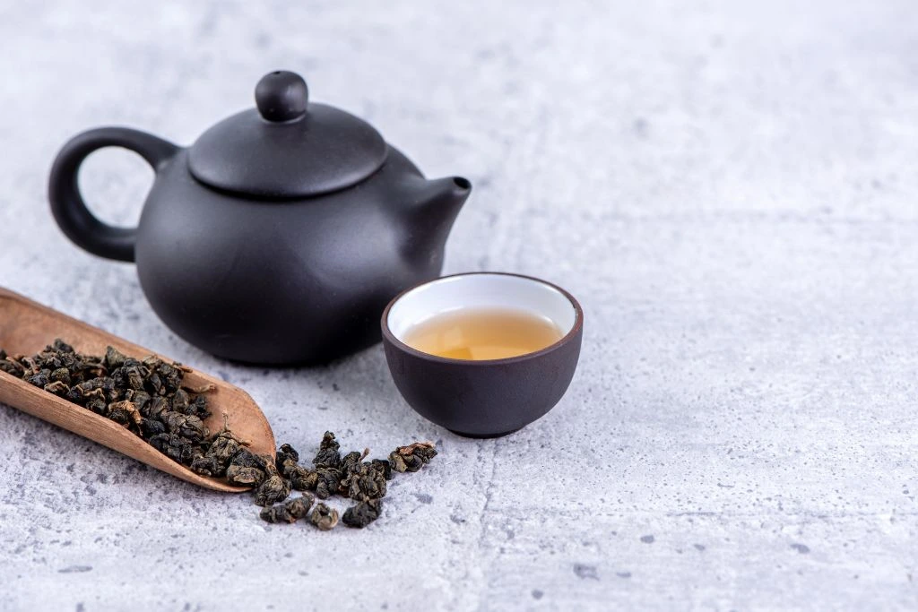 A pot and a cup of tea on a pavement