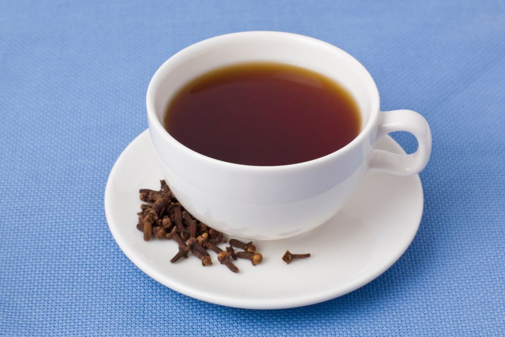 A cup of Clove tea on a ceramic saucer