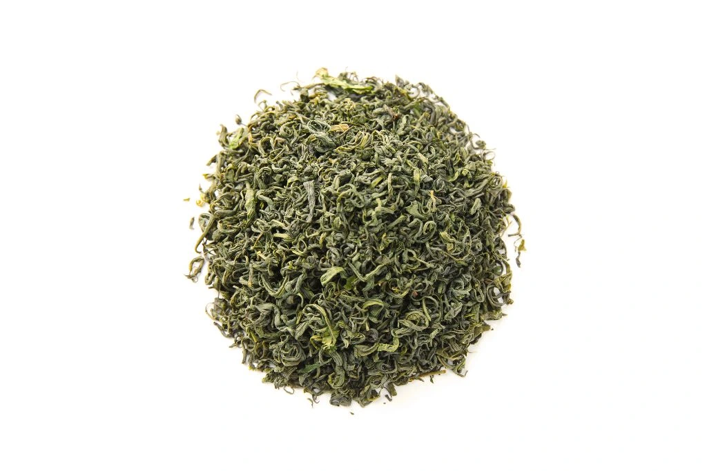 Dried green tea leaves on a white background