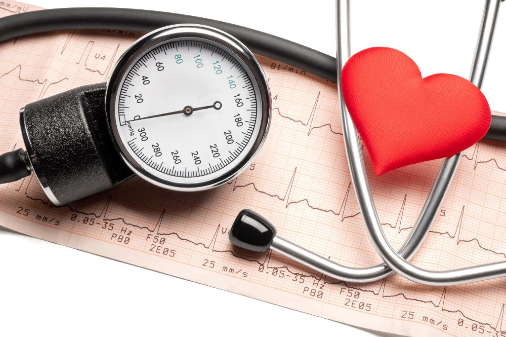 a blood pressure instrument with a red heart-shaped paper beside it