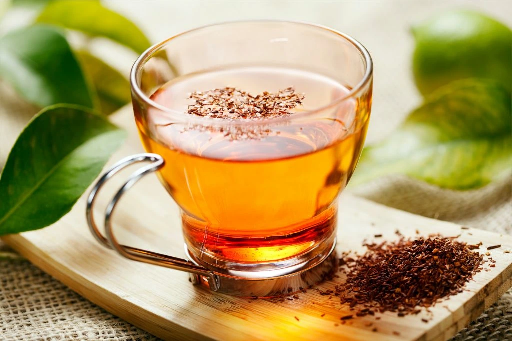 Rooibos tea is poured into a glass jar