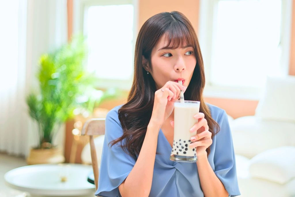 girl drinking her milktea inside her living room