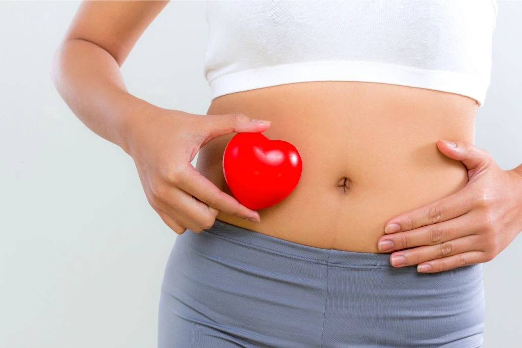 a woman showing her tummy and indicated she has a good digestive cycle
