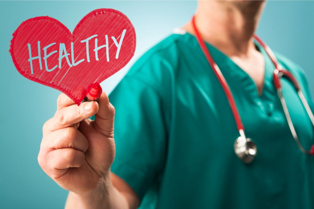 A doctor is holding a red pen and drawing a healthy heart