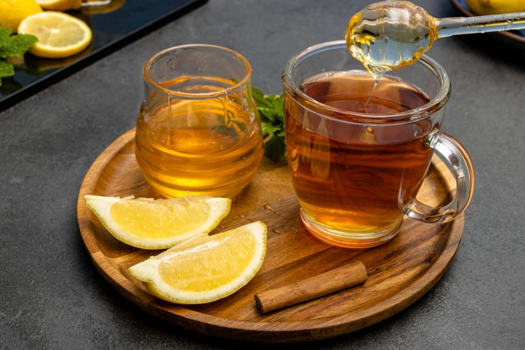 honey tea with lemon poured on two glass jars