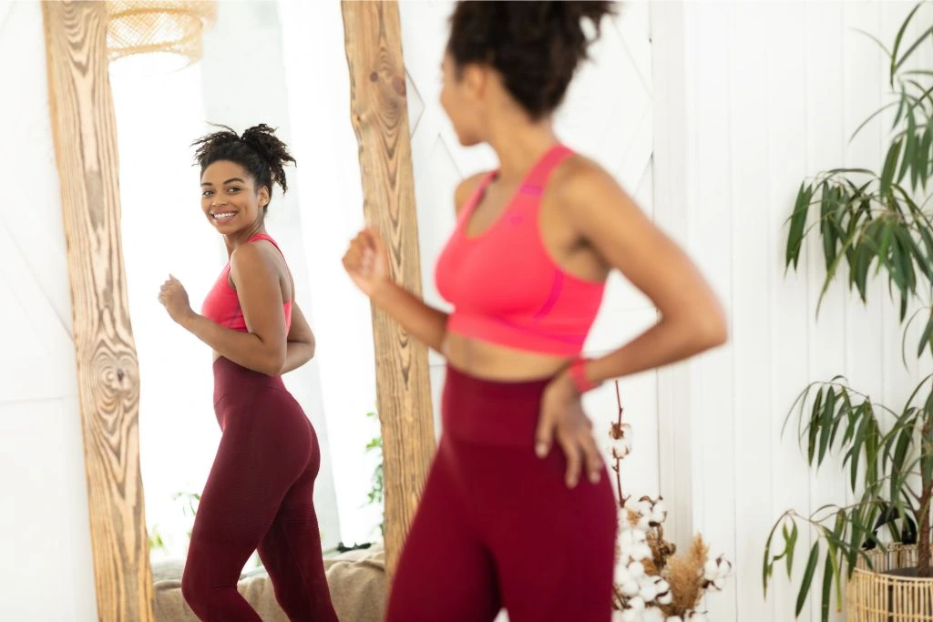 fit and healthy woman looking herself at the mirror 