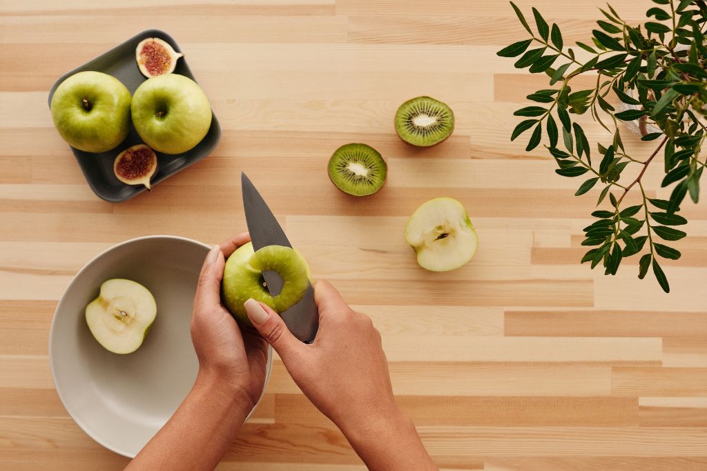 person peeling green apple