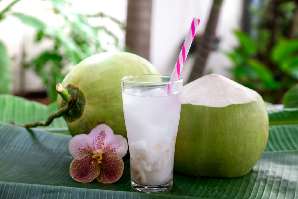 Coconut Iced Tea on a banana leaf with two coconut