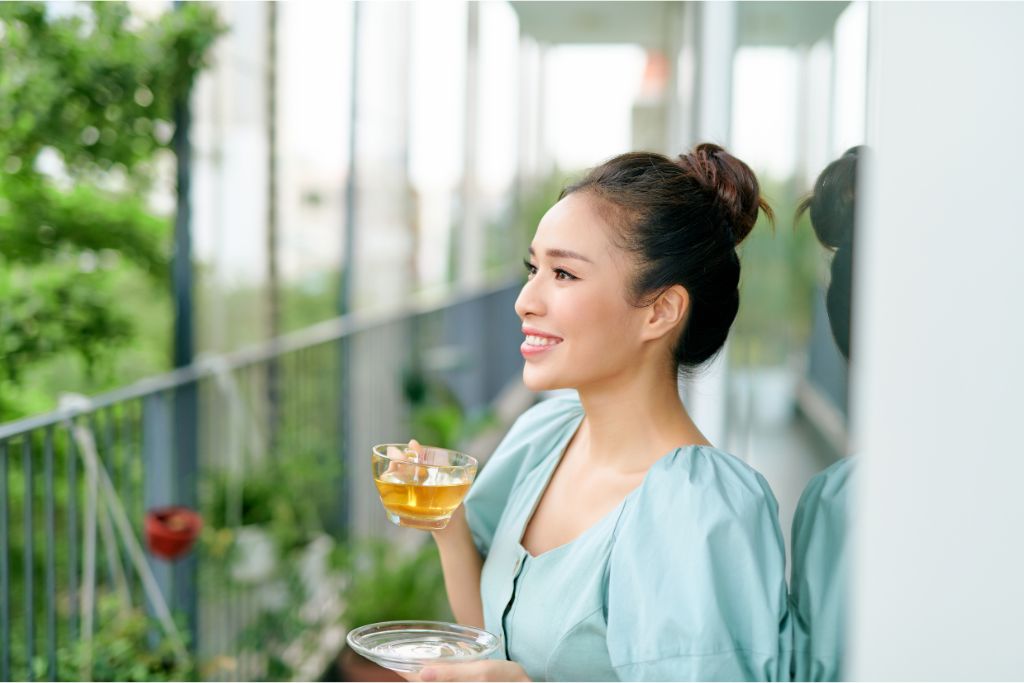 A smiling girl drinking a cup of tea 