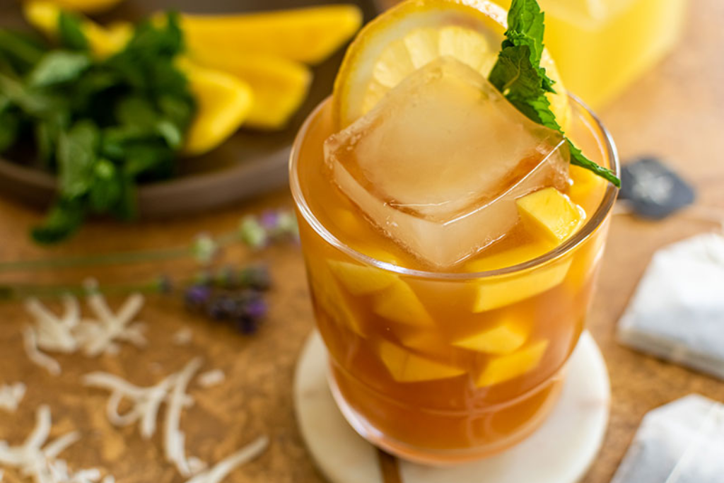 cold Mango Black Tea with a slice of lemon and mango chunks 