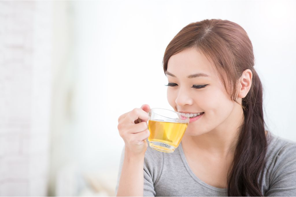 A happy girl drinking tea 