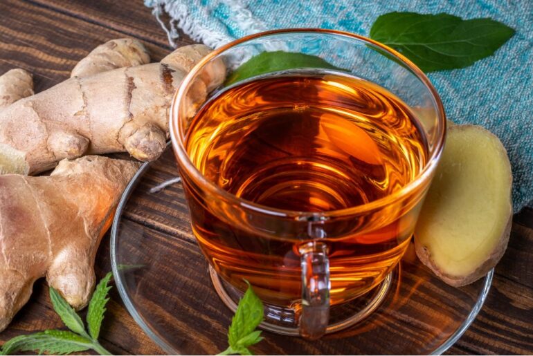 a cup of ginger mint tea on a wooden background