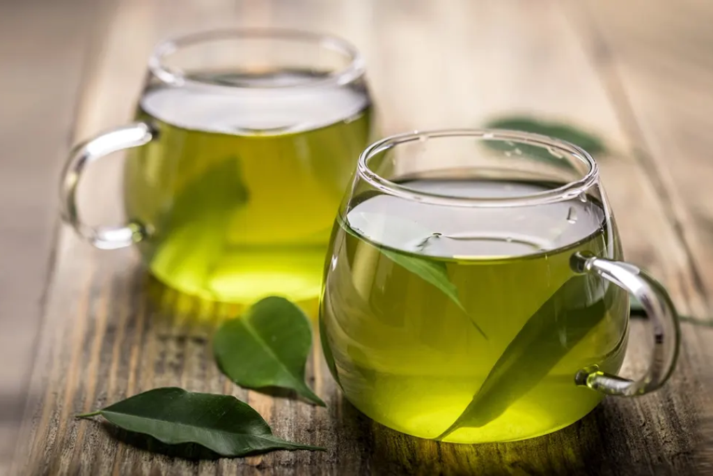 hot cup of green tea on wooden table