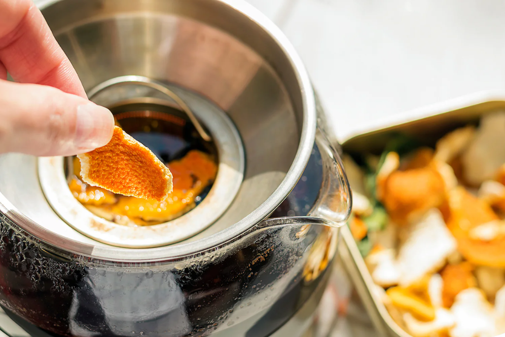 putting dried orange peel on a tea pot 