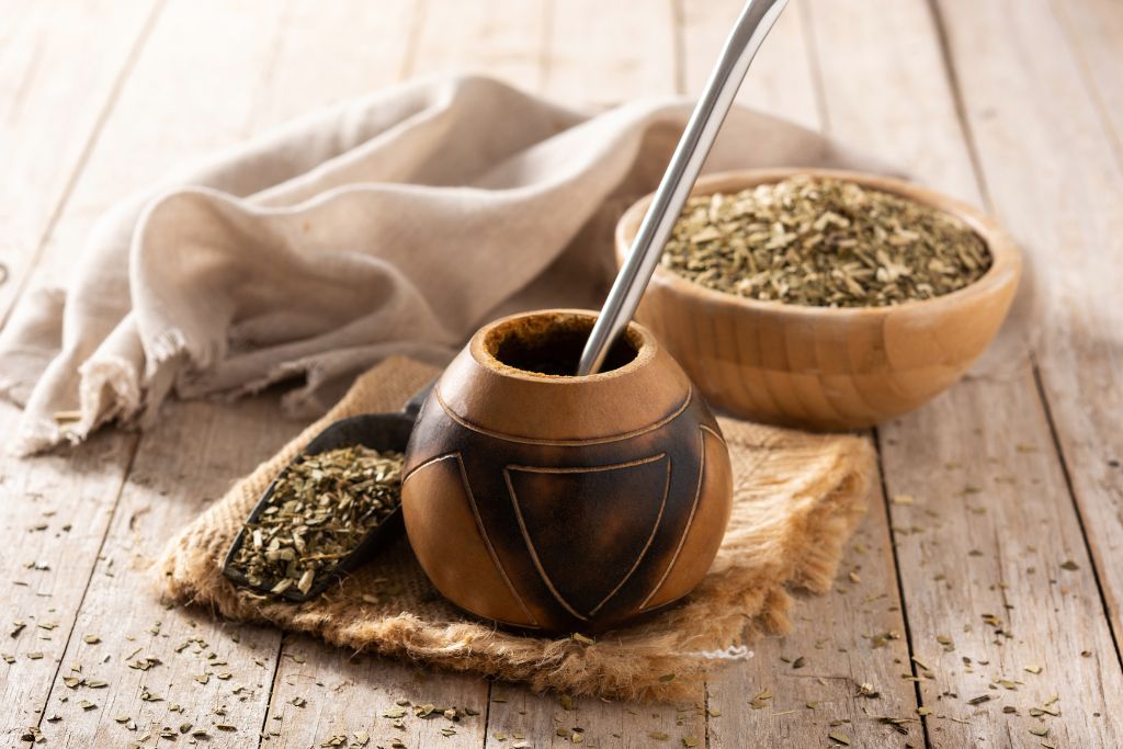 Yerba Mate dried leaves beside a classic looking bowl