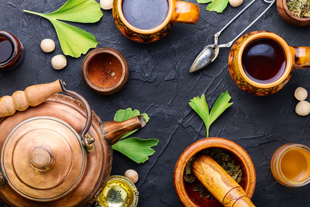 tea utensils and herbs scattered on gray and rough platform