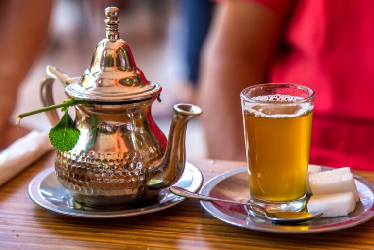 Moroccan mint tea served in a glass together with a silver kettle