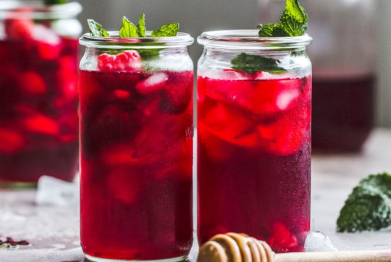 two cold glass of strawberry min tea with ices and mint leaves