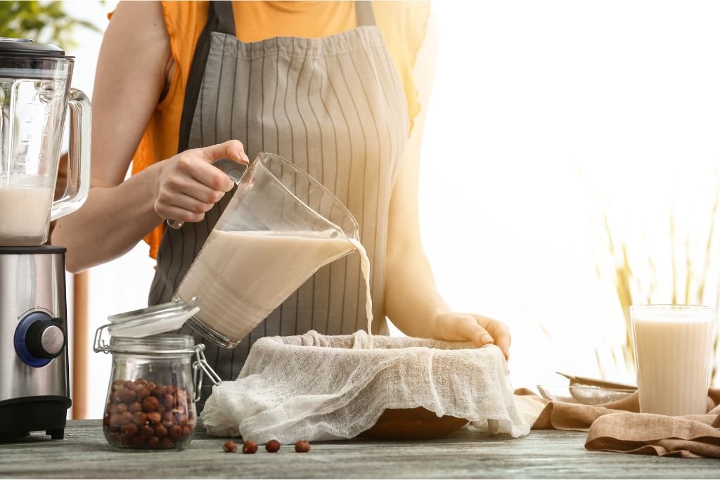 A girl preparing a hazelnut milk to be added on a black tea to make a hazelnut milk tea