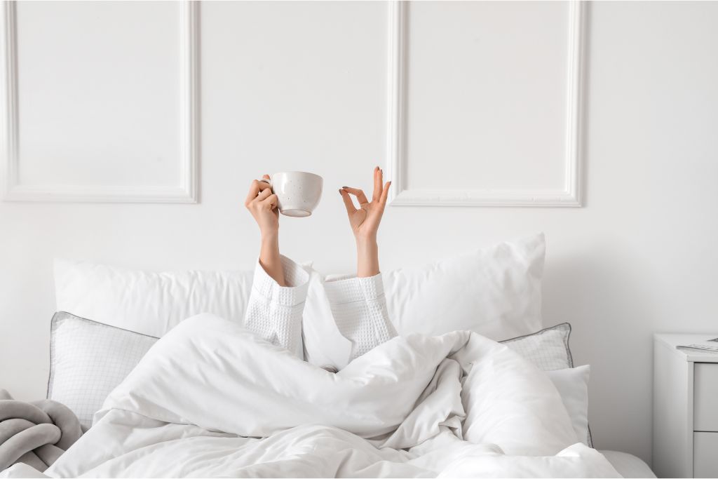 A girl drinking tea in her bed