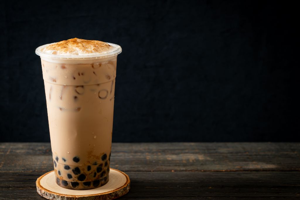 Chai Bubble Tea placed on a wooden coaster on a dark background