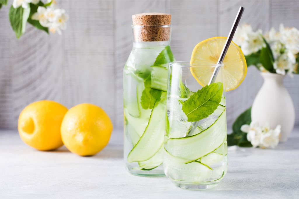 Cucumber with lemon and mint leaves on a drinking glass