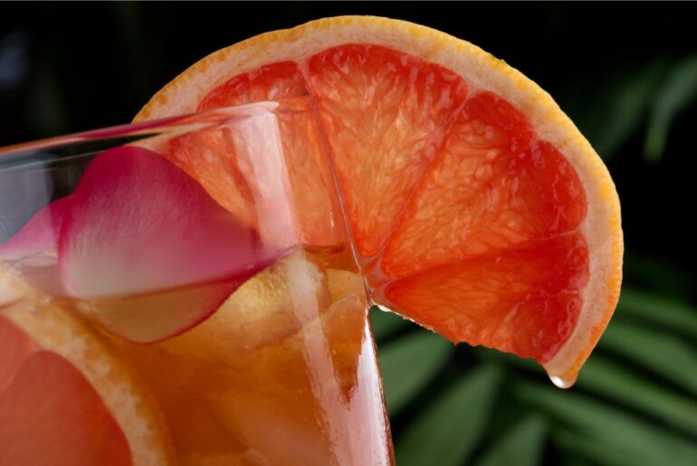 Grapefruit Green Tea on a glass with a sliced grapefruit on it