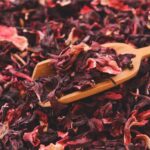 wooden spoon scooping dried hibiscus tea