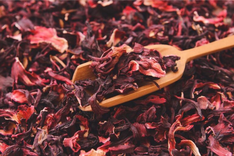 wooden spoon scooping dried hibiscus tea