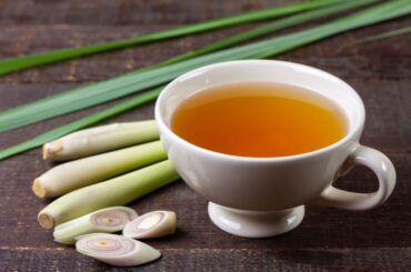 A cup of fresh lemongrass tea in a wooden table with slice lemongrass