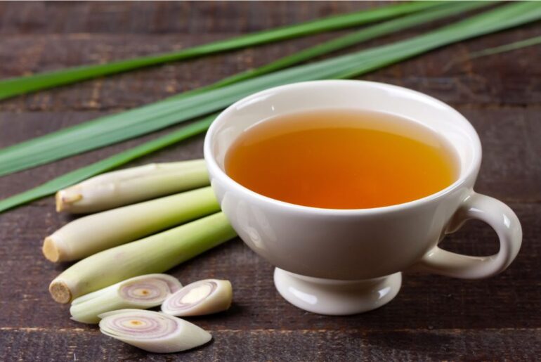 A cup of fresh lemongrass tea in a wooden table with slice lemongrass